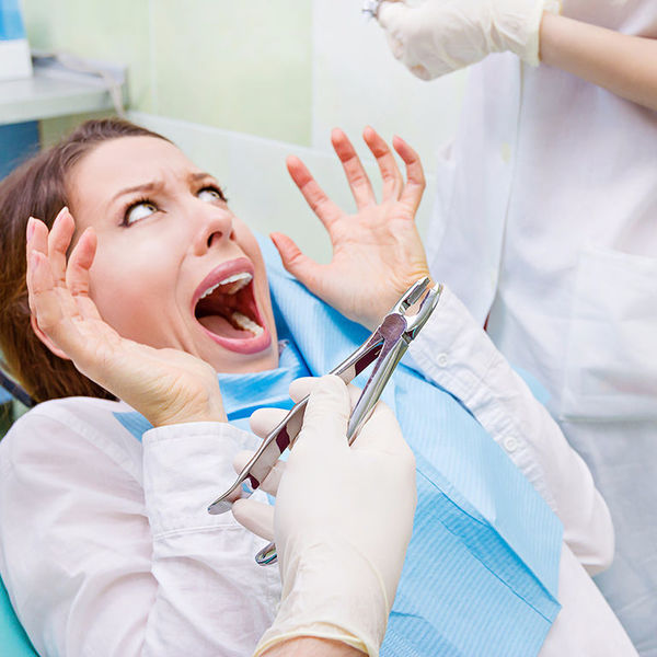 Женщина кричит на приеме у стоматолога